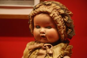 Antique doll wearing a bonnet and dress.