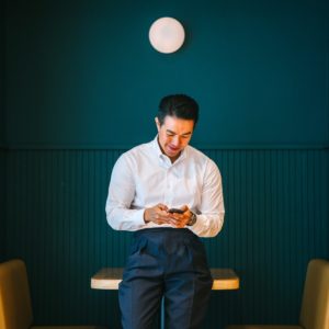 Man holding a smartphone and looking down at it