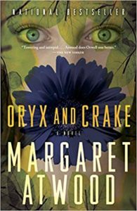 Oryx and Crake by Margaret Atwood book cover. Image is of a woman's face and a flower. 