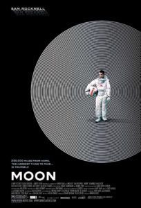Moon film poster. Image on it is of an astronaut wearing a spacesuit and holding his helmet. 
