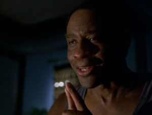 Tim Russ as Tuvok in Star Trek Voyager. Photo is of him suffering from pon farr. He is grimacing and his face is covered in perspiration. 