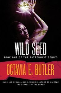 Wild Seed by Octavia E. Butler book cover. Image on cover is of woman holding a glowing root. 