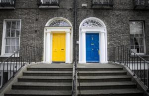 two front doors in a duplex. One door is blue and the other one is yellow