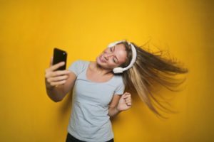 Woman dancing while using headphones and iPhone