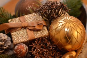 Ornaments, snow-covered pine cone, tinsel, and a wrapped present.