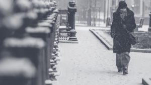 Woman walking down a city street during a blizzard