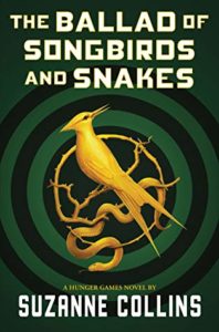The Ballad of Songbirds and Snakes by Suzanne Collins book cover. Image on cover is of a gold mocking jay sitting on a branch. There is a target sign behind it. 