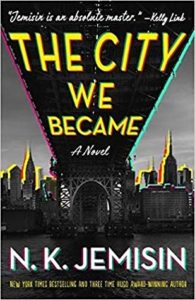 The City We Became by N.K. Jemisin book cover. Image on cover is of the underside of a bridge and the skyline of a large city. 