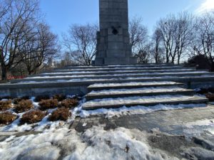 Close-up photo of snow sitting on the steps of a World War I monument. 