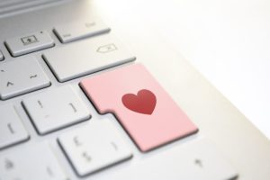 Close-up of a computer keyboard. The "enter" key is pink and has a red heart on it. 