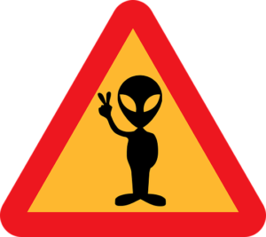 A caution sign with the outline of an alien giving a peace sign on it. 
