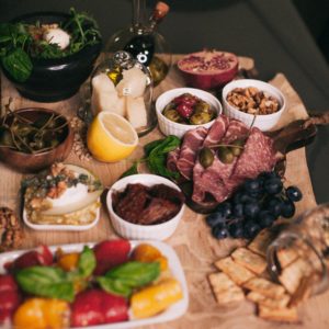 charcuterie board filled with meat, cheese, and fresh vegetables. 