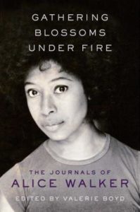 Gathering Blossoms Under Fire- The Journals of Alice Walker by Alice Walker book cover. Image on cover is of the author looking straight ahead with neutral expression on her face.