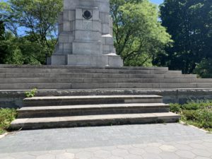 World War I statue surrounded by luscious green trees. 