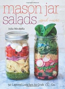 Mason Jar Salads and More- 50 Layered Lunches to Grab and Go  by Julia Mirabella book cover. Image on cover is of two mason jars filled with salad ingredients. 