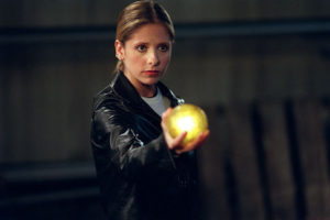 Sarah Michelle Gellar as Buffy Summers in Buffy the Vampire Slayer. She's holding a glowing orb. 