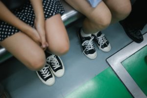 Shot of people's legs and feet as they sit on a bus