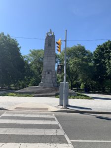 A World War I memorial surrounded by green, lush trees in a park. 