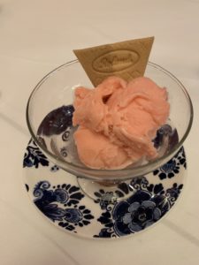 A dairy free fruit sorbet and cracker in a fancy glass dish. 
