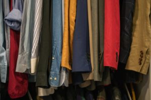 a closet filled with shirts and coats