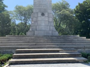 A World War I statue in a park. The statute is surrounded by stone steps.