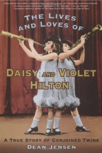 The Lives and Loves of Daisy and Violet Hilton- A True Story of Conjoined Twins by Dean Jensen book cover. Image on cover is of Daisy and Violet playing instruments on a stage.