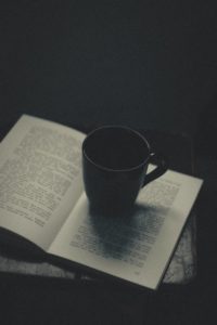ceramic mug sitting on an opened book