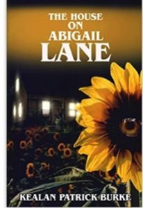 Book cover for The House on Abigail Lane by Kealan Patrick Burke. Image on cover is of a house that has all of its windows illuminated by light on a dark night. It is sitting next to a garden filled with sunflowers, one of which has a human-like eye in the centre of it staring straight ahead at the reader. 