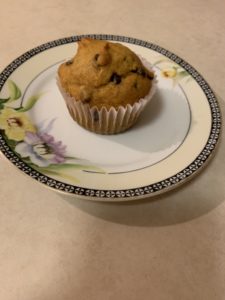 A pumpkin chocolate chip cupcake on a decorative side plate