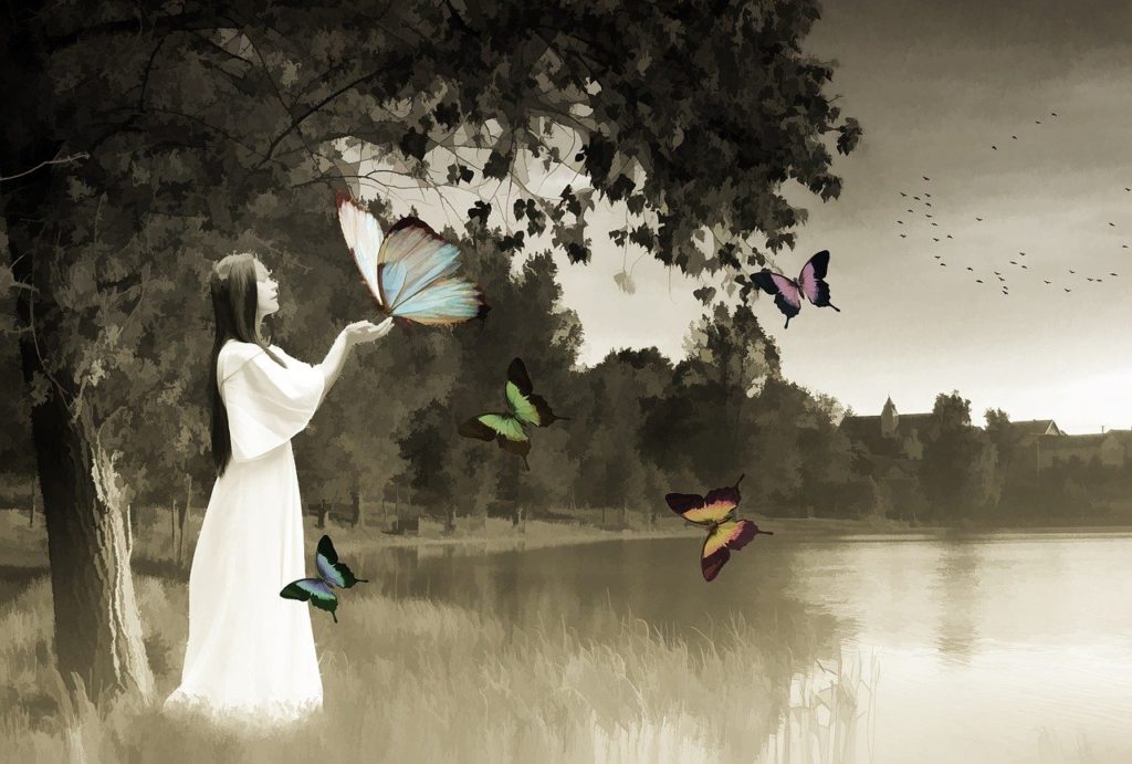 stylized black and white drawing of woman in white dress touching butterflies the size of large owls. the blue, green, orange, and pink butterflies are the only splashes of colour in this scene. 