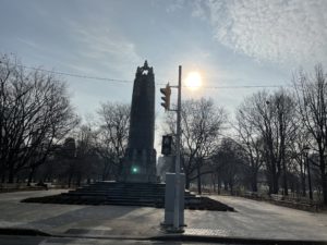 Landscape portrait of a World War II monument at a park in December. All of the trees are bare. 