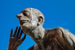 A stone sculpture of someone eavesdropping 