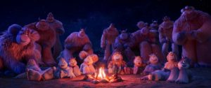 A large group of yetis gathered around a fire listening to stories. 