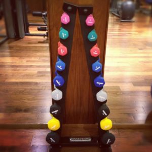 A rack filled with small dumbbells