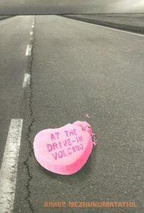 At the Drive-In Volcano by Aimee Nezhukumatathil book cover. Image on cover shows a broken conversation heart on a highway. The title is written in the heart. 