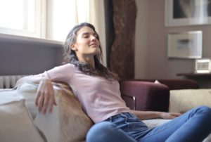  woman closing her eyes while sitting on a couch