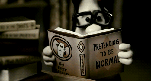 Animated character reading a book that says "pretending to be normal" 