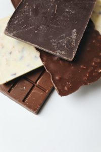 closeup of four chocolate bars with assorted nut and fruit add-ins 