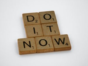 Scrabble blocks spelling out "do it now."