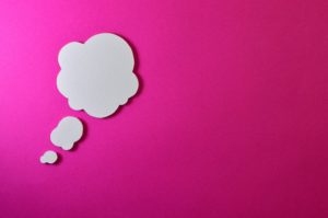 White thought bubbles against a bright pink background 