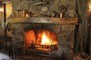 A cozy stone fireplace in a wooden house. 