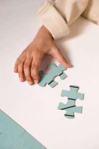 Person putting puzzle pieces together. 