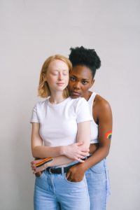 Queer black woman cuddling a queer white woman.