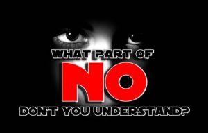 Photo of a person's face half-covered in shadow. Their eyes are visible. The words "what part of no don't you understand" is written on the bottom half of their face.