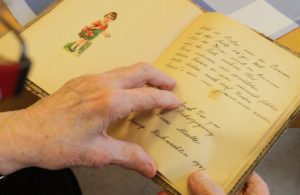 Senior citizen gently touching a memory book. 