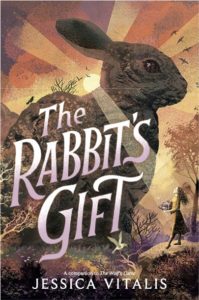 The Rabbit’s Gift by Jessica Vitalis book cover. Image on cover shows a drawing of a brown rabbit that’s as big as a house. A regular-sized woman is standing next to it in a forest and holding a bouquet of flowers as she looks up and gazes upon it. 