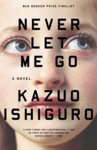 ver Let Me Go by Kazuo Ishiguro book cover. Image on cover shows a close-up of the face of a woman who is looking up with a concerned expression on her face. 