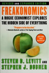 omics: A Rogue Economist Explores the Hidden Side of Everything by Steven D. Levitt book cover. Image on cover shows an apple that has one slice missing. The slice shows that the inside of the apple is actually an orange. 