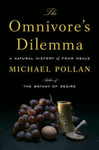 The Omnivore's Dilemma: A Natural History of Four Meals by Michael Pollan book cover. Image on cover shows grapes, an egg, and a few old pieces of pottery sitting together. 