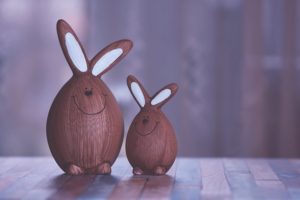 Two Brown wooden bunny figurines. One adult and one child. 
